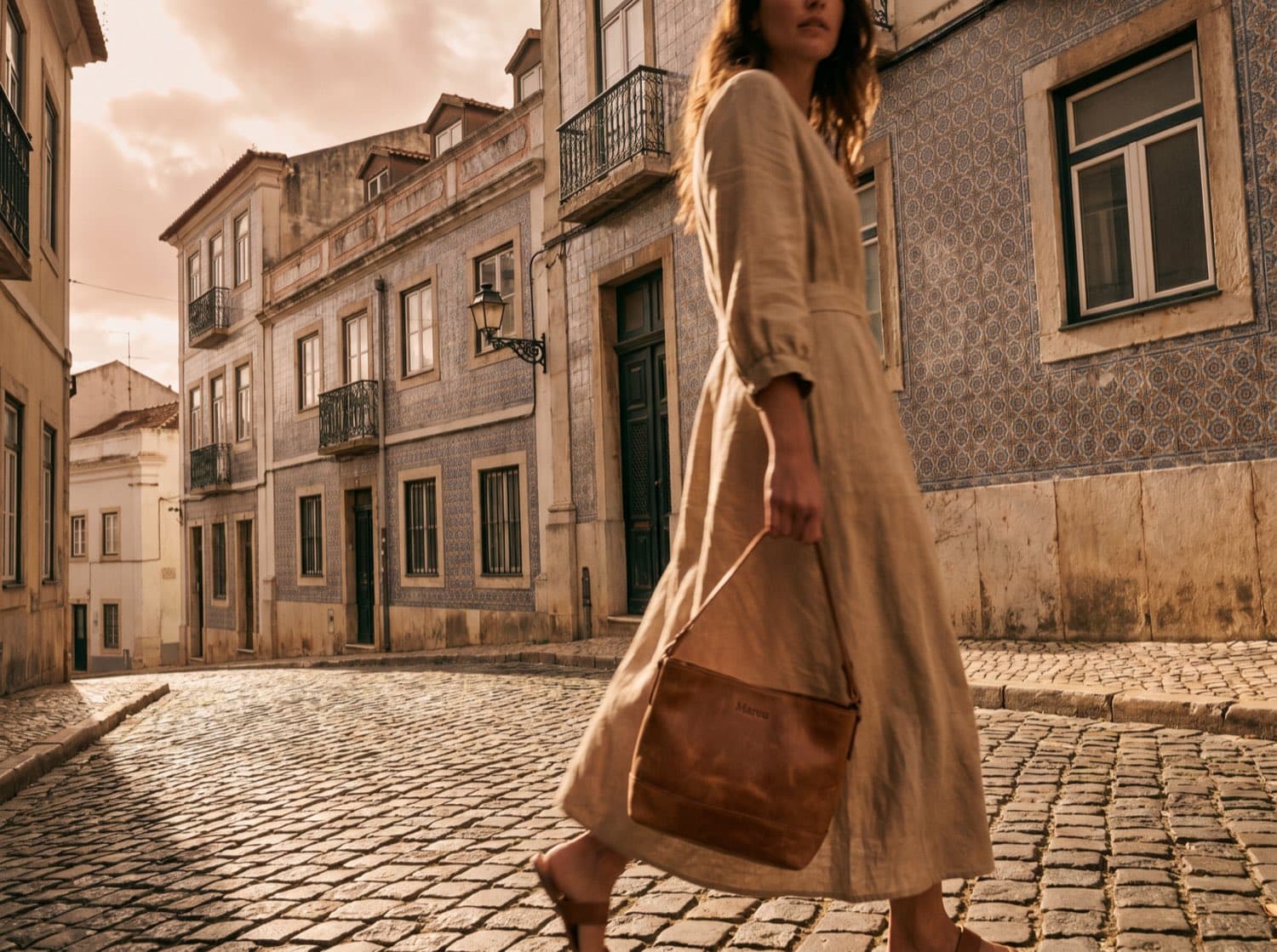 Lookbook-Bild 1 — Lissabon-Gasse, Frau in sand-farbenem Linen-Kleid